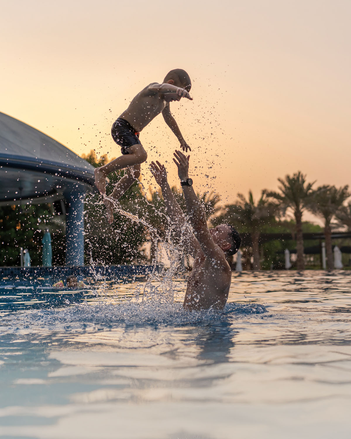 Father playing with son in pool